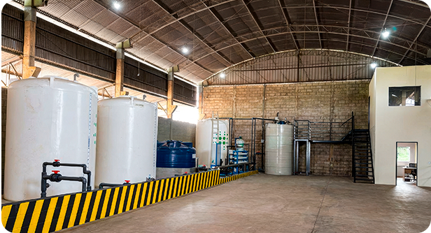 Interior da unidade: tanques, tubulações com válvulas e estrutura administrativa em mezanino.